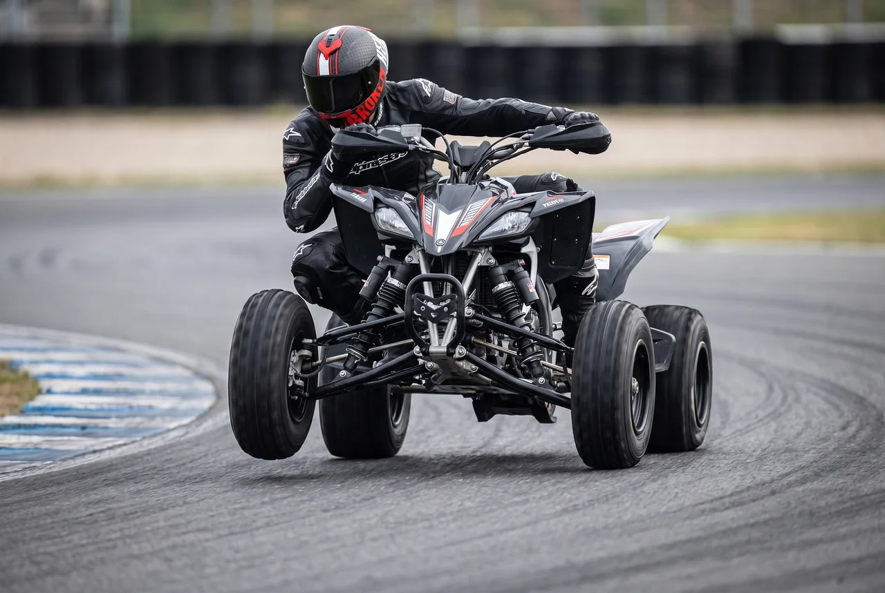 Quadfahrer auf einer Rennstrecke mit geschlossenem Broken Head Helm